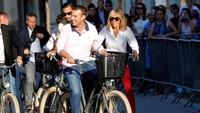 Macron dan istrinya, Brigitte bersepeda santai sehari sebelum pencoblosan. (Foto: REUTERS/Christophe Archambault).