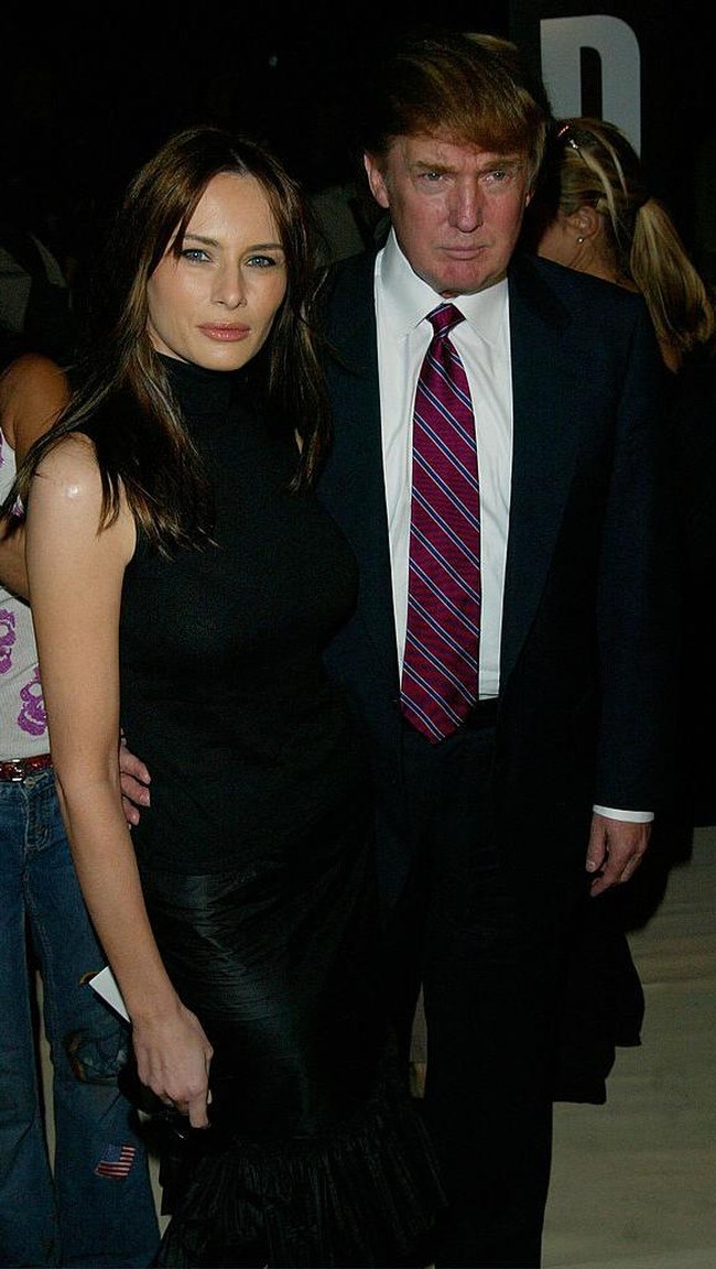 Ketika menjadi tamu di acara fashion show Oscar de la Renta Spring/Summer 2003, Donald Trump juga berpenampilan resmi memakai jas dan dasi panjang bergaris warna marun. Foto: Matthew Peyton/Getty Images