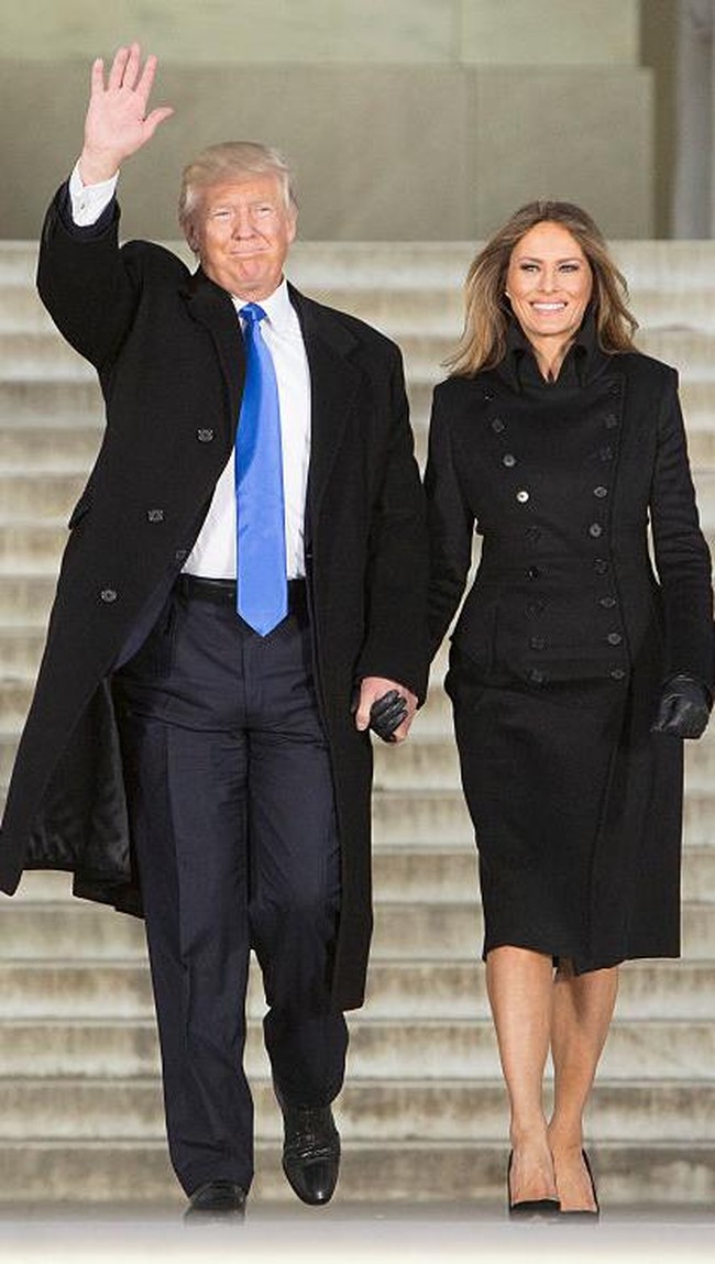 Berbeda dengan momen kali ini ketika Donald Trump memakai dasi biru muda saat menggandeng Melania yang berbaju serba hitam. Foto: Chris Kleponis-Pool/Getty Images