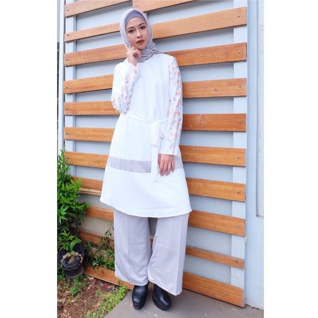 Jika ingin tampil menggunakan tunik bisa lihat inspirasi gaya ala Poppy Bunga untuk Lebaran. Poppy Bunga memakai tunik putih dan celana palazzo abu-abu yang polos sehingga memberikan kesan minimalis nan trendi. Foto: Instagram
