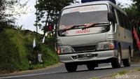 Mobil travel melintas di jalur tersebut.