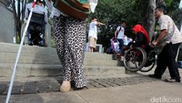 Para penyandang disabilitas menggelar aksi dengan menggunakan kursi roda.