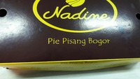 Tiap kotak berisi lima buah pie bentuk pisang. Kotak kemasannya berwarna paduan cokelat dan kuning. 