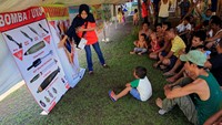 Seorang relawan tengah menjelaskan bom-bom yang tidak meledak kepada pengungsi. REUTERS/Romeo Ranoco.