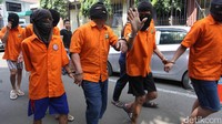 Salah satu tersangka melambaikan tangan saat akan dihadirkan rilis di Mapolda Metro Jaya.