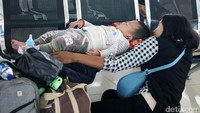 Seorang bayi tertidur di kursi tunggu saat menunggu bus.