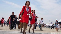 Para pramugari AirAsia tampil modis dengan seragam warna merah yang dikenakannya.