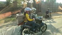 2. Naik motor bertiga di tengah ada anak tanpa menggunakan helm dan di bagian belakang ada kandang burung. Foto: Dok. Istimewa