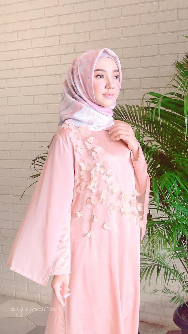 Tampil anggun saat Lebaran dengan inspirasi gaya hijab pastel dari Ayu Indriati. Ia mengenakan dress dengan aplikasi detail yang cantik. Foto: Instagram