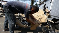 Petugas mengepak motor yang akan dikirim.