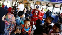 Tak hanya mengecek kondisi kesehatan para pemudik, sejumlah petugas juga terlihat menghibur para pemudik.