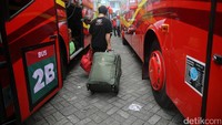 Para pemudik membawa koper dan tas besar.