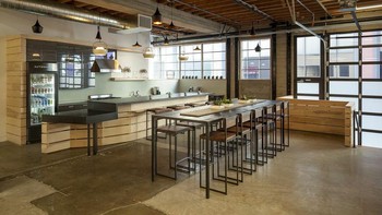 Kantor ini dibangun dari bekas gudang yang dirancang sedemikian rupa.  Atapnya tinggi, dengan pintu-pintu bekas gudang yang dimodifikasi. Foto: Officesnapshots.com