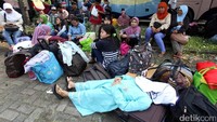 Seorang pemudik tertidur pulas di samping bus yang akan mengantarkan pulang ke kampung halaman.