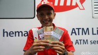 Seorang warga menunjukan uang recehan baru yang ditukar di Bank Mandiri.