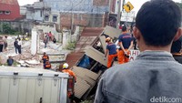 Mobil boks itu langsung terperosok ke bawah. Selain menghantam kios Ahmad, kendaraan tersebut menghancurkan kios tahu milik Ai. Pool/Wisma Putra.