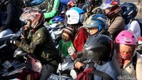 Seorang bocah tampak kelelahan dan tertidur di motor.