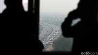 Warga melihat kemacetandi Tol Cikampek dari sebuah gedung.