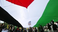 Selama unjuk rasa, para pendemo juga membentangkan sebuah bendera Palestina raksasa.