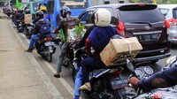 Kebanyakan pemudik bermotor membawa kardus dan tas berukuran besar. 