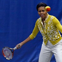 Michelle Obama menerima servis dari lawan mainnya saat bermain tenis di sela kunjungannya ke sebuah sekolah di Washington, 2012, lalu. Ia memukau dengan cardigan kuning berhiaskan motif floral. (Foto: Getty Images)