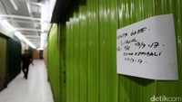 Pedagang menempelkan kertas pengumuman penutupan kios selama libur Lebaran.