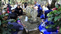 Beberapa warga berdoa di sekitar makam keluarga.