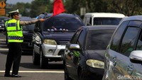 Polisi terjun langsung untuk merapikan antrean kendaraan.