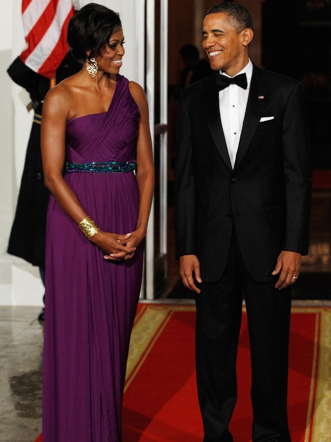 Michelle Obama dalam balutan gaun ungu berbahu asimetris saat menyambut Presiden Korea Selatan Lee Myung-bak di Gedung Putih, 2011 lalu. Foto: Getty Images