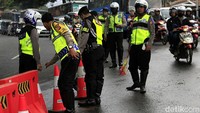 Polisi menutup jalur menuju Limbangan saat petugas Diskar berjibaku membersihkan tumpahan solar.