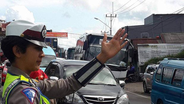 Polisi mengatur arus lalu lintas di jalur Puncak, Senin (26/6/2017)