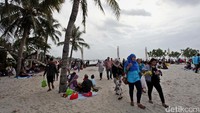 Para pengunjung menikmati suasana pantai.