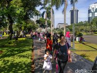 Warga menikmati suasana kawasan Monas.