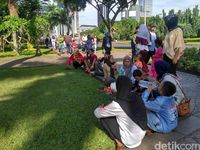 Warga menikmati suasana di Taman Monas.