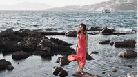 Dengan balutan dress warna merah muda, Nikita Willy mempesona berdiri diantara batu karang. Foto: Instagram Nikita Willy