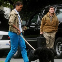 Michelle Obama mengandalkan sneakers kesayangannya untuk menemani jalan-jalan bersama Bo, anjing peliharaannya. (Foto: Getty Images)