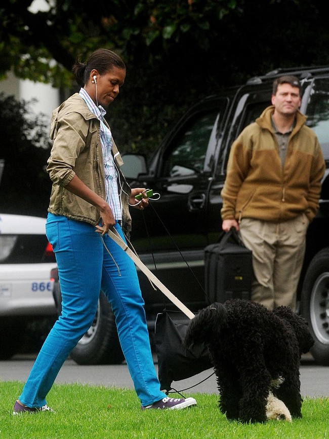 Michelle Obama mengandalkan sneakers kesayangannya untuk menemani jalan-jalan bersama Bo, anjing peliharaannya. (Foto: Getty Images)