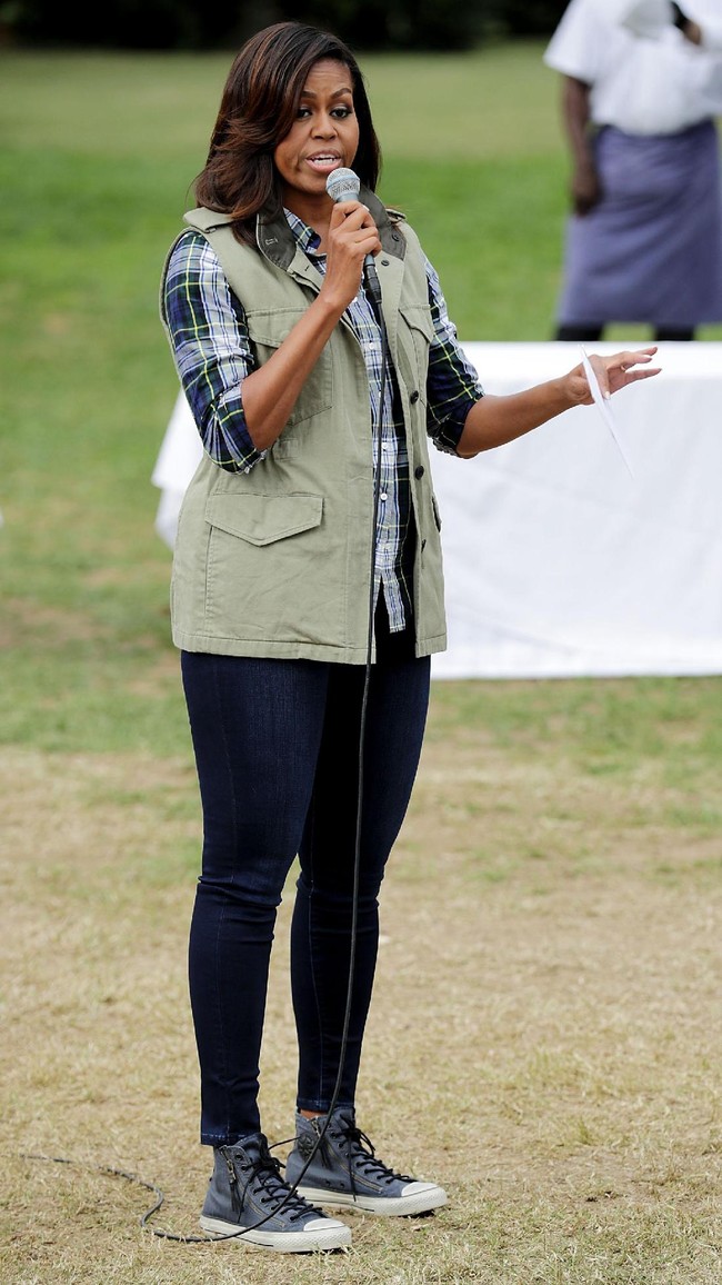 Kemeja kotak-kotak, vest, jeans, dan sneakers. Paduan yang tidak mengecewakan bagi Michelle Obama. (Foto: Getty Images)