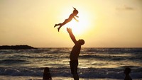 Seorang pria nampak bermain dengan sang anak di Pantai Mediterania. REUTERS/Amir Cohen.