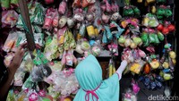 Seorang anak terlihat memilih beberapa boneka.