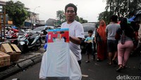 Seorang warga usai memborong sejumlah mainan di Pasar Gembrong.