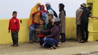 Nampak sejumlah warga berswafoto di pendestrian jembatan dengan latar perkampungan dan perkebunan Desa Laksana. Pool/Wisma Putra.