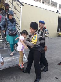 Polisi membantu warga yang turun dari KM Dodonsolo.