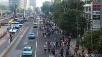 Ratusan warga beraktivitas di kawasan Bundaran Hotel Indonesia, Jakarta, Minggu (2/7/2017).