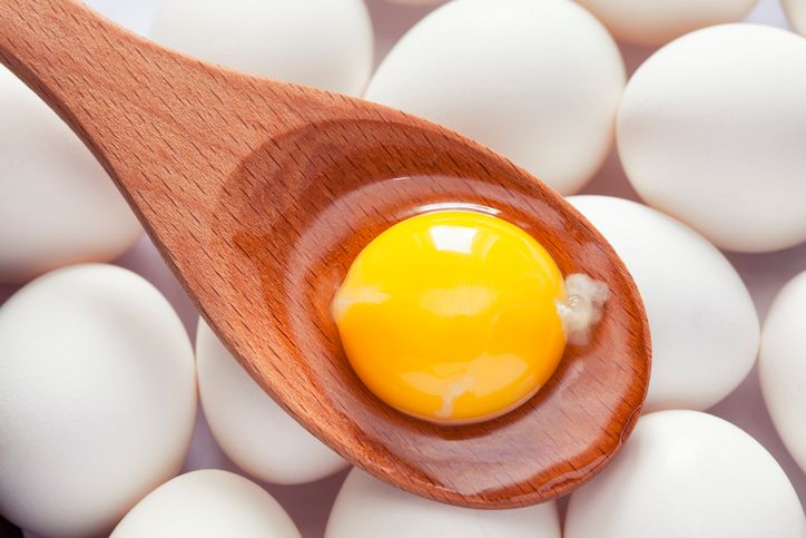 Eggs and Egg yolk in paper tray on wood