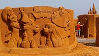 Karakter dari Lady and The Tramp lucu juga ya bila diukir di pasir (Yves Herman/ REUTERS).