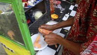 Pedagang rujak melayani warga.