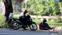 Pemudik motor menepikan kendaraannya untuk beristirahat.