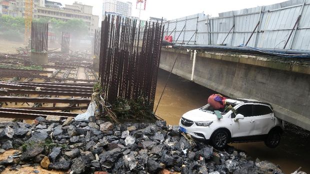 Mobil yang terbawa arus banjir terdampar di bawah jembatan di Provinsi Guangxi