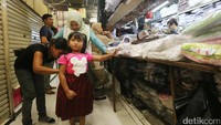Seorang anak menjajal baju seragam merah putih untuknya.